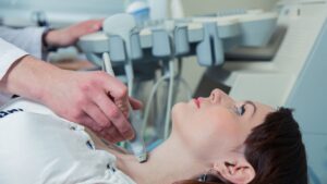 un medico sta facendo un'ecografia tiroidea ad una paziente
