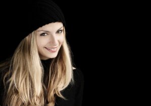 Una ragazza bionda sorride mostrando una dentatura perfetta