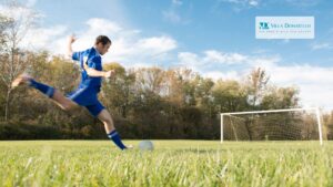un ragazzo sta per calciare un pallone in porta su un campo di calcio