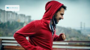 Un ragazzo dalla felpa rossa corre affaticato