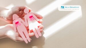 due mani tengono il fiocco rosa dedicato alla prevenzione dei tumori alla mammella