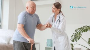 una dottoressa aiuta un malato di Parkinson a camminare